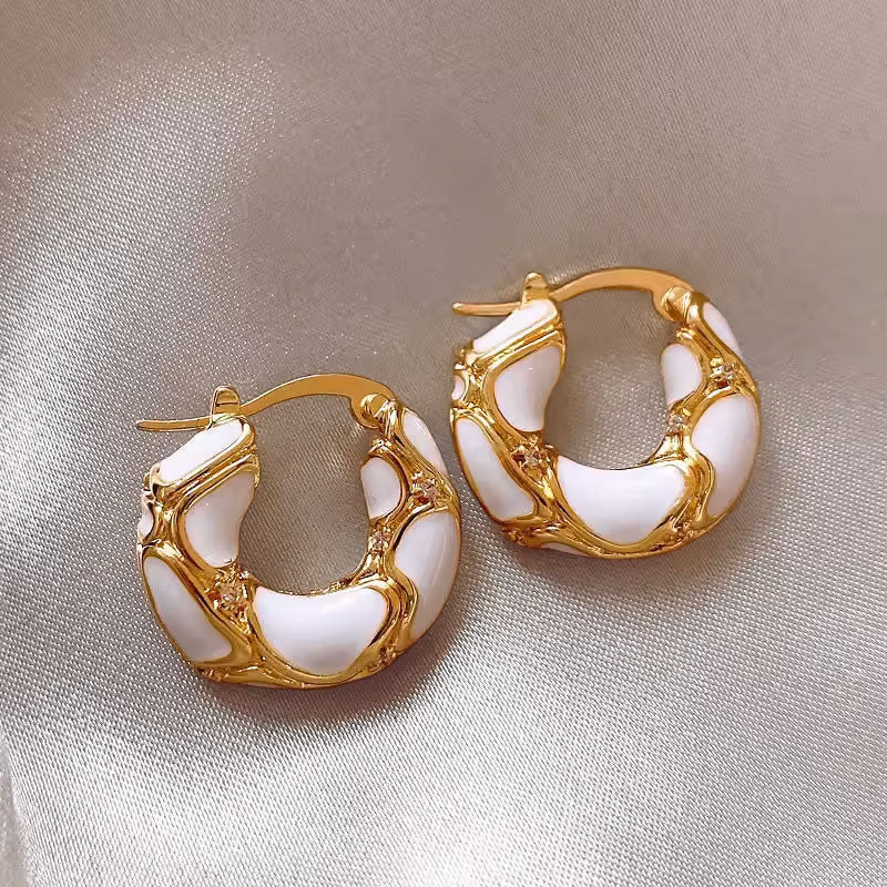 Aros grandes dorados con detalles de esmalte blanco